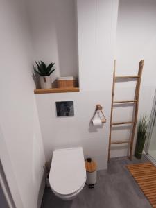 La salle de bains est pourvue de toilettes blanches. dans l'établissement Harmony Apartment, à Ostróda