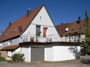 a large white house with a balcony at Ferienwohnung Die Schmiede in Schopfloch