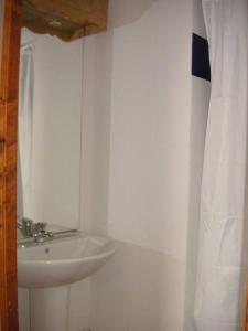 łazienka z umywalką i białą zasłoną prysznicową w obiekcie Appartement lumineux à Orcières 1850 w mieście Orcières