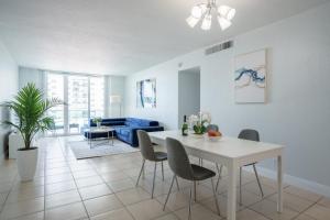 - un salon avec une table et des chaises blanches dans l'établissement Modern 1 BDR Oceanview with direct beach access!, à Hollywood