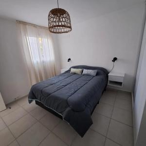 a bedroom with a large bed with a blue blanket at Departamento Temporario La Plaza in Córdoba