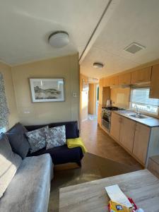 a living room with a couch and a kitchen at Jone’s Cove in Swanage