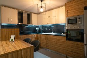 伊拉克利翁鎮的住宿－Nefele Maisonette near Heraklion centre，厨房配有木制橱柜和木桌。