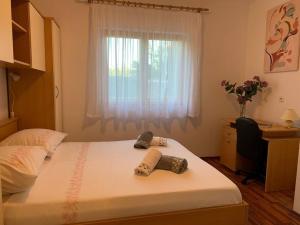 a bedroom with a bed with a desk and a window at Tranquil verde in Matulji