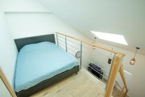 een slaapkamer met een bed en een trap bij KASA FACTORY - Au calme - TV & WIFI in Saint-Quentin