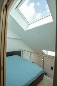 een slaapkamer met een bed en een dakraam bij KASA FACTORY - Au calme - TV & WIFI in Saint-Quentin
