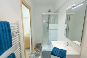 een badkamer met een wastafel en een spiegel bij KASA FACTORY - Au calme - TV & WIFI in Saint-Quentin