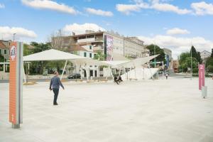 un hombre parado en una plaza con una gran tienda blanca en Hortensia, en Šibenik 8 fotos más