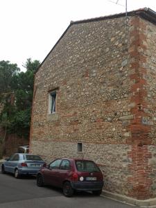 dos coches estacionados frente a un edificio de ladrillo en Maison familiale centenaire de vigneron, en Montescot