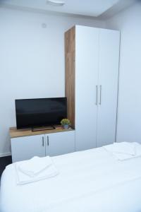 1 dormitorio con 2 camas y TV en un armario en Vb apartmani, en Prijedor