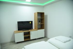 un salon avec une télévision à écran plat sur une armoire dans l'établissement Vb apartmani, à Prijedor