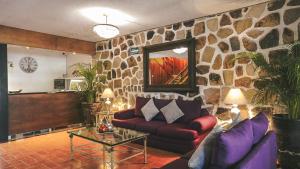 a living room with a couch and a stone wall at Toca Madera in Chapala