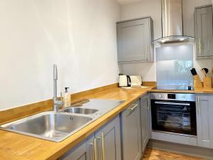 a kitchen with a sink and a stove at The Yorkshire Hosts - The Tailor's Lounge in Ripon