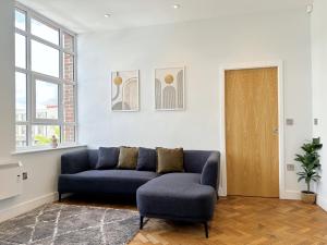 a living room with a blue couch and a chair at The Tailor's Lounge - Central Flat Ripon & Parking in Ripon