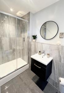 a bathroom with a shower and a sink and a mirror at The Yorkshire Hosts - The Tailor's Lounge in Ripon