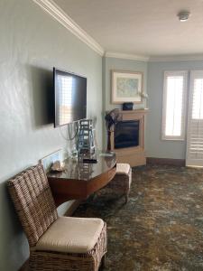 a living room with a table and chairs and a television at Blue Dolphin Inn in Cambria
