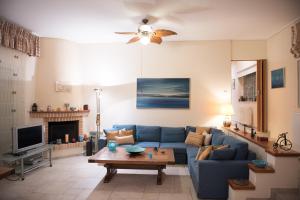 a living room with a blue couch and a tv at Our Dreamhouses in Loutraki Heraion Sea Lake in Loutraki