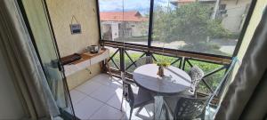 balcón con mesa, sillas y ventana en Flat Studio 11 Hotel Fazenda Gravatá-PE, en Gravatá