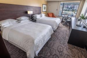 a hotel room with two beds and a desk at Sheraton Quito in Quito +136 photos