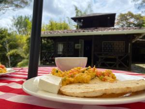 a plate of food with bread and cheese on a table at Cabaña rústica la Pradera in Guatapé
