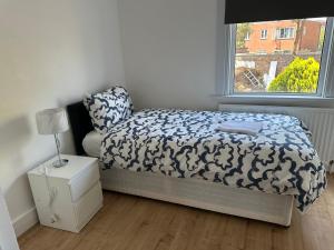 a small bedroom with a bed and a window at Beautiful 4 bedroom house in Enfield in Enfield Lock