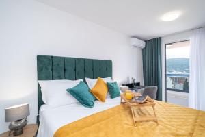 sypialnia z łóżkiem z zielonym zagłówkiem i stołem w obiekcie Luxury Villa Salt w mieście Slano