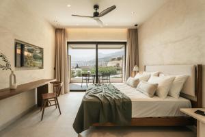 a hotel room with a bed and a large window at AMÉNTE Mindful Stay in Plakias