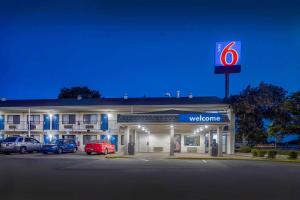 una señal de bienvenida frente a un hotel con coches aparcados delante en Motel 6-Hammond, IN - Chicago Area, en Hammond