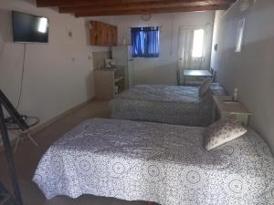 a small bedroom with two beds and a television at La Yuma en Villars in Villars +7 photos
