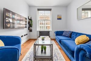 a living room with a blue couch and a table at Stylish 2 bedroom apartment in Westminster Sleeps 5 with AC in London