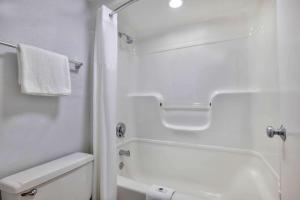 y baño blanco con aseo y ducha. en Motel 6-Hammond, IN - Chicago Area, en Hammond