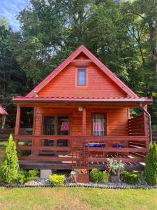 a log cabin with a red roof at Chaty Mazur w Wierzbie in Ruciane-Nida
