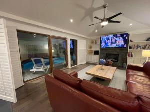 een woonkamer met een bank en een tv bij Lux White Rock Pool House Beachfront Resort like in Surrey