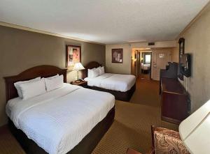a hotel room with two beds and a television at Clarion Inn Garden City in Garden City