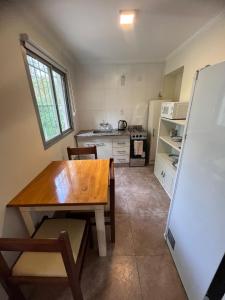 una cucina con un tavolo di legno e un frigorifero di Bella vista a Saldungaray Altre 2 foto