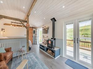 a living room with a couch and a tv and a fireplace at The Liddel Dutch Barn - Uk44465 in Saughtree
