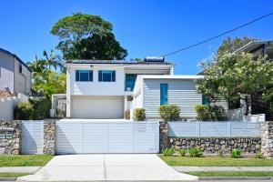 a white house with a fence at Stylish 2 b/r apartment - 4 guests, garage ZC5 in Alexandra Headland