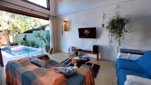 sala de estar con sofá y TV en Casa Canto dos Saíras, en Paraty