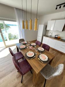a dining room with a wooden table and chairs at Dream View Villa in Jadranovo
