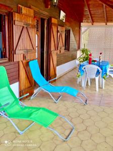 un par de sillas y una mesa en un patio en Chez Ninette près des sources chaudes, en Bouillante