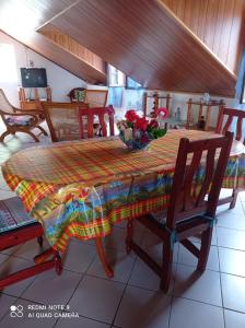 a dining room table with a colorful table cloth on it at Chez Ninette près des sources chaudes in Bouillante