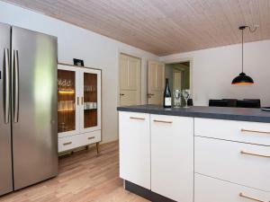 cocina con armarios blancos y nevera de acero inoxidable en Holiday home Rømø XVII en Rømø Kirkeby