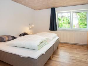 sypialnia z dużym łóżkiem i 2 oknami w obiekcie Holiday home Rømø XVII w mieście Rømø Kirkeby