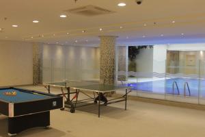 a room with a ping pong table and a swimming pool at Mandarin Hotel Apartments in Riyadh