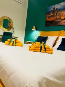 a bed with yellow towels and a laptop on it at B&B Palermo Pirri in Palermo