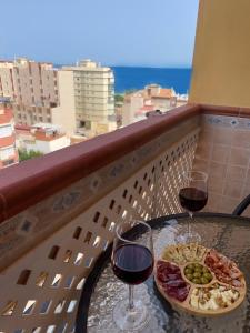 a table with two glasses of wine and a plate of food at Estudio Oceanview Torre del Mar in Torre del Mar