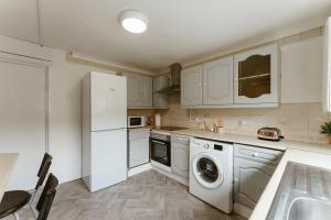 una cucina con frigorifero bianco e lavastoviglie di CanningTown Double Rooms - 20 a Londra