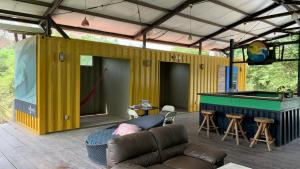ein gelbes Haus mit einem Billardtisch und einer Couch in der Unterkunft EL TUMBO in Rivas