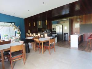 a kitchen and dining room with tables and chairs at Apartamento Garden em condomínio clube in Florianópolis