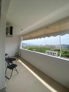 a room with a balcony with two chairs and a window at The Flip-Flop Apartment in Shëngjin